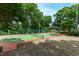 Private tennis court surrounded by mature trees and greenery, with ample space for recreation at 812 Kenmore Rd, Chapel Hill, NC 27514