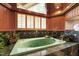 Beautiful bathtub area with tile and granite surround, accented with shuttered windows at 812 Kenmore Rd, Chapel Hill, NC 27514