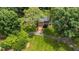 An aerial shot reveals a well-kept brick home amidst a green landscape with mature shade trees at 820 Kenmore Rd, Chapel Hill, NC 27514
