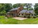 Home's brick and siding exterior features a screened in porch and beautiful backyard patio at 820 Kenmore Rd, Chapel Hill, NC 27514