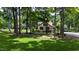 Lush backyard featuring mature trees, green lawn, and glimpses of a charming home at 820 Kenmore Rd, Chapel Hill, NC 27514