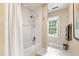 Well-lit bathroom features a tiled bathtub/shower with white accents and a window bringing in natural light at 820 Kenmore Rd, Chapel Hill, NC 27514