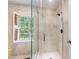 Modern bathroom featuring a glass-enclosed shower and a window with a scenic view at 820 Kenmore Rd, Chapel Hill, NC 27514