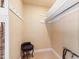 Organized walk-in closet with white shelving, a chair, and hanging rods at 820 Kenmore Rd, Chapel Hill, NC 27514