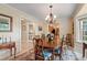 Charming dining room featuring a wooden table, chandelier, and decorative rug, seamlessly connects to other living spaces at 820 Kenmore Rd, Chapel Hill, NC 27514