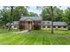 A traditionally-styled brick home offers classic curb appeal with stately columns and lush landscaping at 820 Kenmore Rd, Chapel Hill, NC 27514