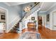 Grand foyer featuring a staircase, hardwood floors, elegant chandelier, and decorative rug at 820 Kenmore Rd, Chapel Hill, NC 27514