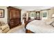 Relaxing bedroom featuring windows, neutral walls, hardwood floors and a carved wood bed frame at 820 Kenmore Rd, Chapel Hill, NC 27514
