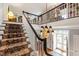 Staircase leading to an upper floor, with an ornate chandelier, rug runner and an open design at 820 Kenmore Rd, Chapel Hill, NC 27514