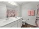 A well-lit bathroom with a double sink vanity and a floral-themed shower curtain at 10 Forest Brook Way, Clayton, NC 27520