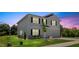 Two-story home exterior with black shutters, landscaping, a green lawn, and landscape lighting at 10 Forest Brook Way, Clayton, NC 27520