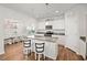 Open floor plan kitchen featuring granite countertops, bar stools, stainless appliances and white cabinetry at 10 Forest Brook Way, Clayton, NC 27520