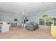 Spacious bedroom with large windows, ceiling fan, a seating area, and a cozy queen bed at 1003 Burnt Hickory Ct, Apex, NC 27502