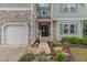 Inviting home featuring a stone facade, attached garage, and manicured landscaping at 1003 Burnt Hickory Ct, Apex, NC 27502