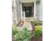Inviting front porch with stone accents, well-manicured landscaping with flowers and a welcoming entrance at 1003 Burnt Hickory Ct, Apex, NC 27502