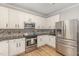 Modern kitchen with white cabinets, stainless appliances, and stylish backsplash at 1003 Burnt Hickory Ct, Apex, NC 27502
