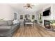 Cozy living room with fireplace, light gray sofa, wood flooring, and lots of natural light at 1003 Burnt Hickory Ct, Apex, NC 27502