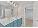 Primary bathroom featuring a double sink vanity with large mirror and modern light fixture at 10603 Friendly Neighbor Ln, Raleigh, NC 27614