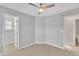 A cozy carpeted bedroom with a ceiling fan and doors to the bathroom and closet at 10603 Friendly Neighbor Ln, Raleigh, NC 27614