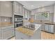 Beautifully designed kitchen features an island with a cooktop, granite countertops, and stainless appliances at 10603 Friendly Neighbor Ln, Raleigh, NC 27614