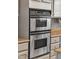 Close-up of stainless steel, double oven, and granite countertops with gray cabinets at 10603 Friendly Neighbor Ln, Raleigh, NC 27614