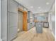 Well-lit kitchen featuring gray cabinets, an island with a cooktop, and modern appliances at 10603 Friendly Neighbor Ln, Raleigh, NC 27614