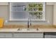 Close up of a kitchen sink with black faucet, grey cabinets and a double window above at 10603 Friendly Neighbor Ln, Raleigh, NC 27614