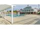 Large community pool with covered pergola and view of the clubhouse on a bright, sunny day at 10603 Friendly Neighbor Ln, Raleigh, NC 27614