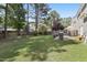 Large backyard showcasing a well-maintained lawn, a patio with seating, and mature trees, offering a private outdoor space at 107 Trackimire Ln, Apex, NC 27539