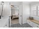 Open bathroom with a view to the main bedroom, featuring patterned tile flooring and a white vanity with black hardware at 107 Trackimire Ln, Apex, NC 27539