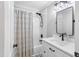 Well-lit bathroom showcasing a modern vanity, black hardware, and a shower/tub combination with a stylish curtain at 107 Trackimire Ln, Apex, NC 27539