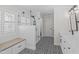 Bathroom showcasing a tiled glass shower, bench seating, black and white patterned tile floor, and white cabinets at 107 Trackimire Ln, Apex, NC 27539