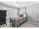 Cozy bedroom featuring a patterned bedspread, neutral walls, and a ceiling fan, creating a comfortable and inviting space at 107 Trackimire Ln, Apex, NC 27539