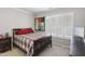 Cozy bedroom featuring neutral walls and carpet, a wooden bed, and window shutters at 107 Trackimire Ln, Apex, NC 27539