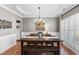 Comfortable dining room with hardwood floors, a stylish chandelier, and shuttered windows at 107 Trackimire Ln, Apex, NC 27539