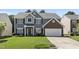 Traditional two-story home boasts manicured lawn, gray siding, and a two-car garage at 107 Trackimire Ln, Apex, NC 27539