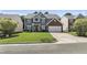 Charming two-story home with a well-manicured lawn, a brick facade, and an attached garage, offering curb appeal at 107 Trackimire Ln, Apex, NC 27539
