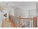 Upstairs hallway with hardwood floors and views of the entry and a secondary bedroom at 107 Trackimire Ln, Apex, NC 27539
