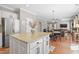 Open-concept kitchen with island seating flows seamlessly into the dining area and living space at 107 Trackimire Ln, Apex, NC 27539