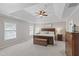 Spacious main bedroom featuring a tray ceiling, ceiling fan, neutral walls and carpet, and a decorative wooden bed frame at 107 Trackimire Ln, Apex, NC 27539