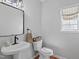 Chic powder room with a pedestal sink, modern fixtures, and a stylish mirror for guests' convenience at 107 Trackimire Ln, Apex, NC 27539