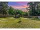 Spacious fenced-in backyard with a shed, fire pit, and lush green grass at 109 St Marys St, Garner, NC 27529