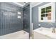 Stylish bathroom featuring a tub and shower with blue tile and modern fixtures and vanity at 109 St Marys St, Garner, NC 27529