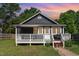 Charming home at dusk with a welcoming front porch and a neat yard at 109 St Marys St, Garner, NC 27529