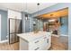 Well-lit kitchen with stainless steel refrigerator, center island, white cabinets, and hardwood flooring at 109 St Marys St, Garner, NC 27529