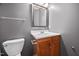 Bathroom with wooden vanity, patterned mirror, and standard toilet at 10941 Pendragon Pl, Raleigh, NC 27614