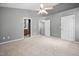 Bedroom featuring neutral carpet, ceiling fan, grey walls, bathroom and closet access at 10941 Pendragon Pl, Raleigh, NC 27614
