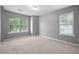 Neutral bedroom with grey walls, carpet, and natural light from two windows at 10941 Pendragon Pl, Raleigh, NC 27614