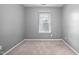 Bedroom with neutral carpet and paint, featuring a window with blinds at 10941 Pendragon Pl, Raleigh, NC 27614