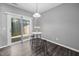 Bright eating area with sliding glass door, white table, stools, pendant lighting, and dark wood floors at 10941 Pendragon Pl, Raleigh, NC 27614